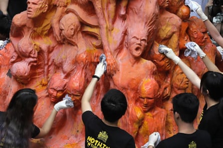 Pro-democracy protesters clean the Pillar of Shame statue, a memorial for those killed in the 1989 Tiananmen crackdown, at the University of Hong Kong, on 4 June 2019.