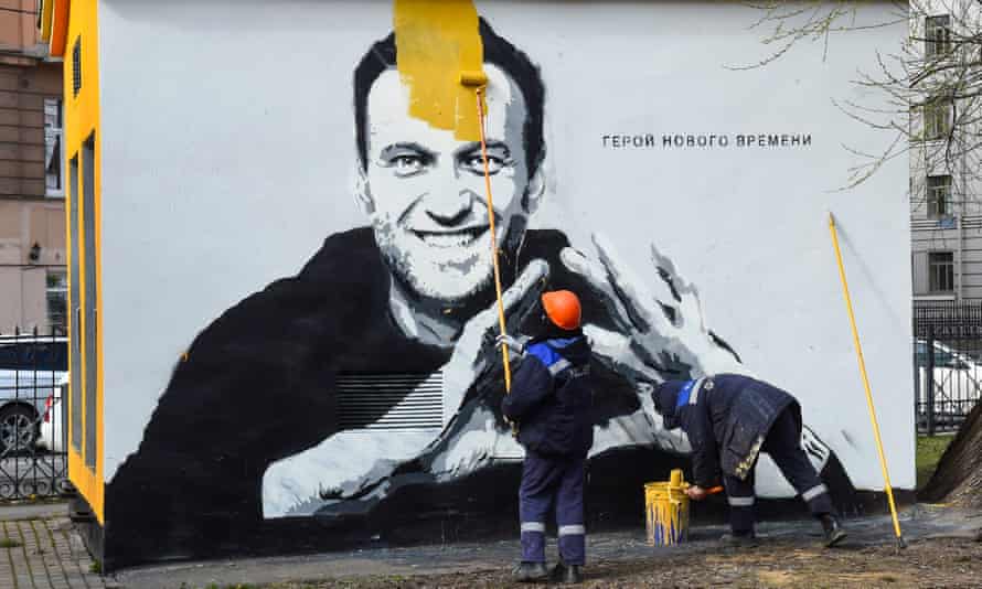 Un ouvrier peint des graffitis sur le critique emprisonné du Kremlin Alexei Navalny à Saint-Pétersbourg.