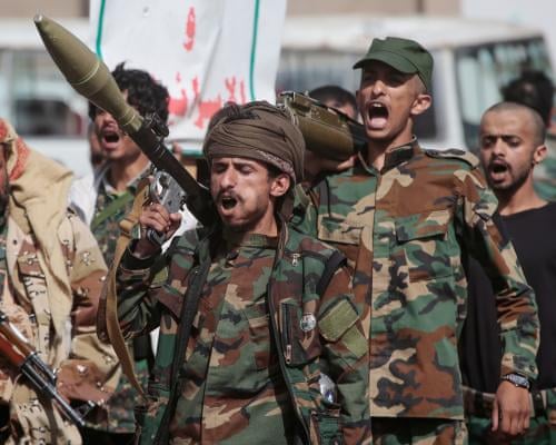 Houthi rebels march during a mobilisation campaign in Sana’a: they wear camouflage and are shouting, and one appears to be carrying a missile.