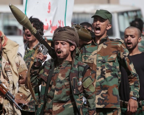 Houthi rebels march during a mobilisation campaign in Sana’a: they wear camouflage and are shouting, and one appears to be carrying a missile.