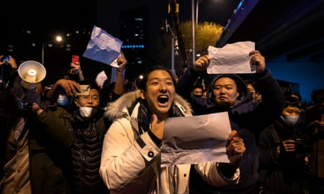 A protester shouts while holding up a blank piece of A4 paper