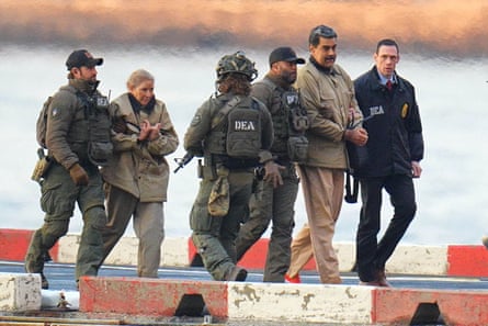 Nicolás Maduro and his wife, Cilia Flores, in handcuffs being escorted by armed federal agents.