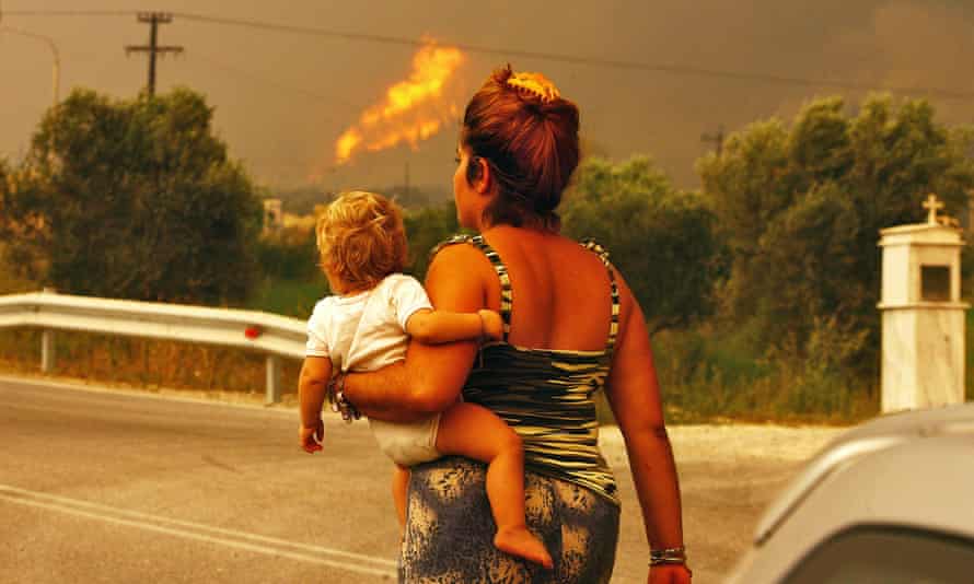 A woman and baby escape the burning village of Platanos