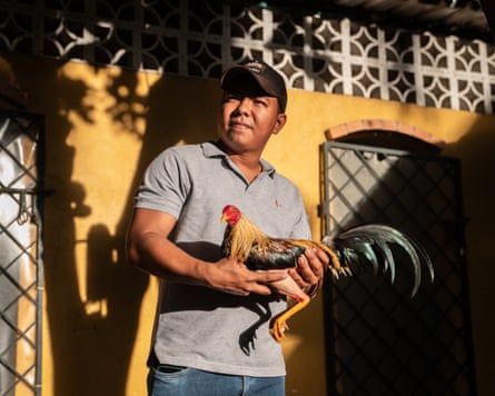 Man in gray shirt holds rooster