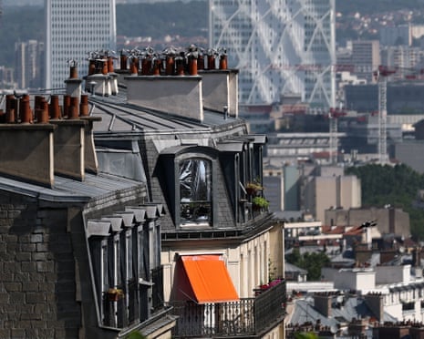 The windows of a Haussmann-style residential building are covered with emergency blankets to shield them from the sun, as temperatures rise in Paris, France.