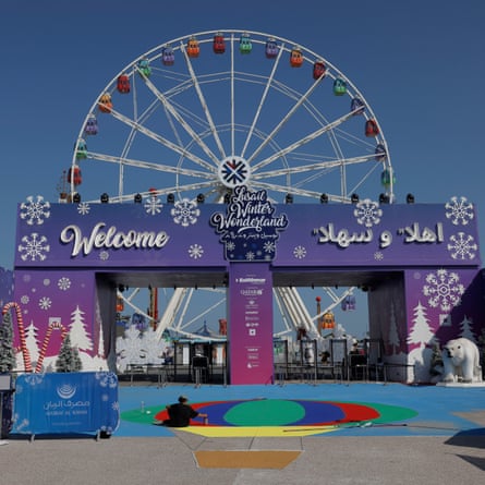 A worker painting in the midday sun at the entrance to the Lusail Winter Wonderland on the man-made island of Al Maha.