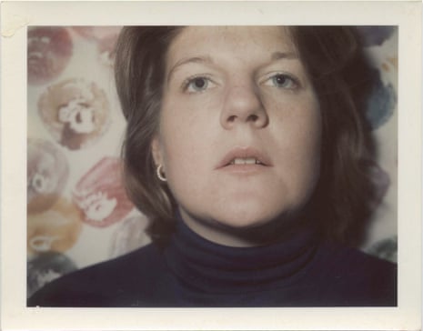 A self-portrait Polaroid photograph by Brigid Berlin, with a background of her Tit Prints, made by dipping her breasts in paint and smearing them on to paper.