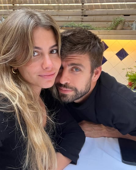 Clara Chia Marti (long blond hair) and Gerard Pique (cropped hair and beard) close up in a clinch, both dressed in black