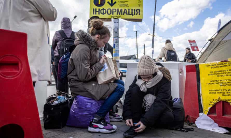 Беженцы из Украины ждут автобуса 8 апреля 2022 года после пересечения украинско-польской границы на пограничном переходе в Медике на юго-востоке Польши.