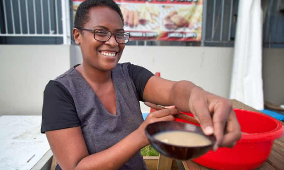 A woman enjoys a bowl of kava at the Kava Bure in Suva.