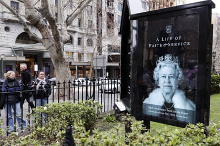 People stop to look at a portrait of Queen Elizabeth II on an electronic noticeboard in Melbourne on 10 September.