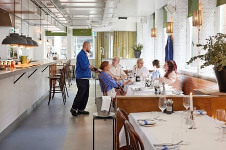 A group of people sat at a table in the interior of Winsome restaurant in Manchester.