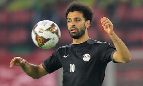 Salah, arms raised, has his eye on the ball.