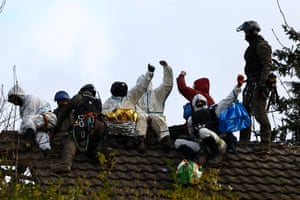 Luetzerath, Germany: A police officer stands on the roof as activists take part in a protest against the expansion of the Garzweiler open-cast lignite mine of Germany’s utility RWE