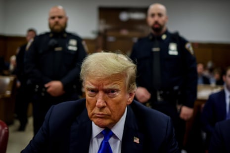 Trump in court with officers behind him.