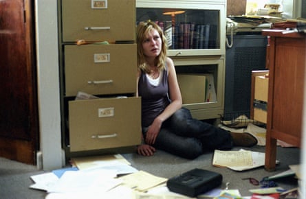 تجلس دونست على الأرض في مكتب منهوب، الأوراق مبعثرة من حولها، تبدو مرهقة