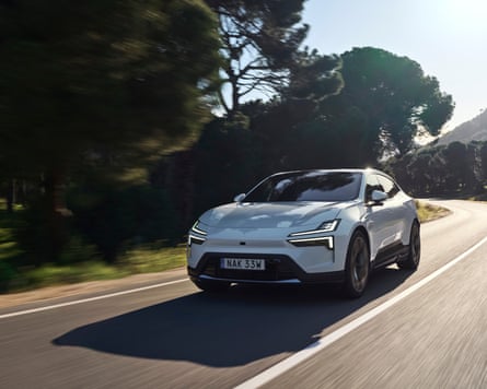 A white Polestar 4 driving along a country road
