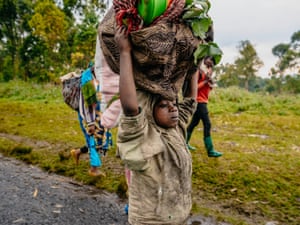 A family displaced by fighting between M23 rebels and the Congolese army flee with their possessions