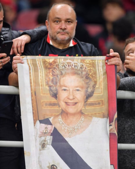 A royalist AC Milan fan displays a banner of Queen Elizabeth II