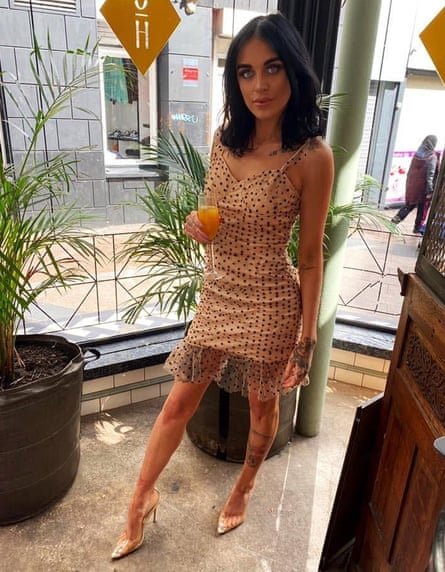 Rachel Roftis stood holding a drink in a bar