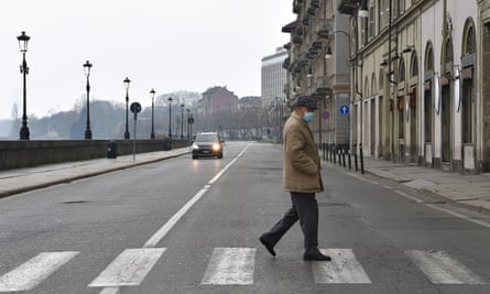 A lone pedestrian crosses the road in Turin