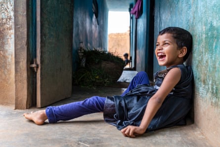 Manisha Kumari Mahto sits on the ground with her back against the wall, looking happy