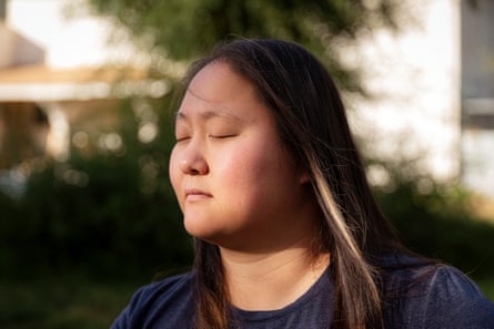 A woman closes her eyes while posing outside for a portrait