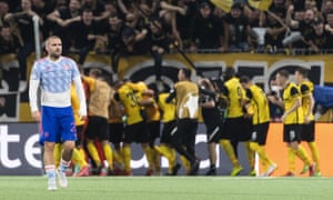 Manchester's Luke Shaw looks dejected as Young Boys celebrate after scoring during of the Champions League group F soccer match between BSC Young Boys and Manchester United, at the Wankdorf stadium in Bern, Switzerland, Tuesday, Sept. 14, 2021. (Alessandro della Valle/Keystone via AP)