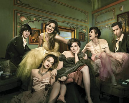 The Girls cast, including Driver and Dunham, pose in a room in evening dress. The girls are wearing elaborate gowns and jewellery while Driver wears a black jacket and white shirt.