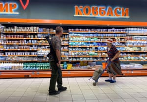 A Ukrainian serviceman and an elderly woman buy food at a supermarket near Kramatorsk