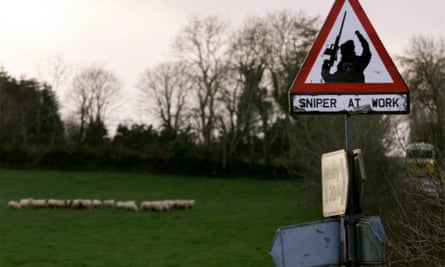 Sheep graze next to a ‘sniper at work’ sign in rural South Armagh in 1999.