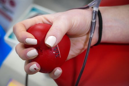 hand holds soft ball while donating blood
