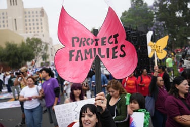 a person holds a sign that reads ‘protect families’