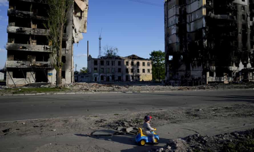 Un niño juega frente a las casas destruidas por los bombardeos en Borodyanka, Ucrania, el martes 24 de mayo de 2022.