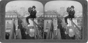 black and white photo of man sitting on beam in city and taking photo