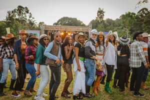 a line of people wearing a mix of fashions including western wear
