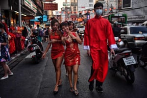 People wear traditional Chinese outfits as they walk in Chinatown in Bangkok, Thailand