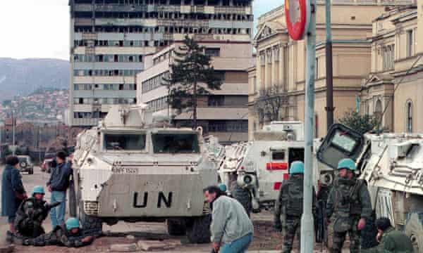 UN peacekeepers and Sarajevo citizens take cover from gunfire on the city's infame 'Sniper Alley', Março de 1993.