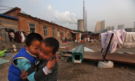 Chinese boys play in the courtyard of their home beside a power plant  in Beijing, China, 28 November 2011. Reports state that China, the world's largest emitter of greenhouse gases, is rallying key allies to push developed nations to agree to binding targets for reducing carbon emissions ahead of climate change talks in Durban even as it maintains that developing countries continue to be exempt as these would hamper efforts to alleviate poverty
