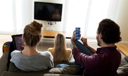 Friends in living room, using digital devices