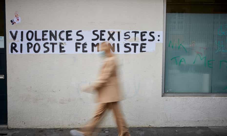 A woman walks past an anti-femicide poster in Paris, France