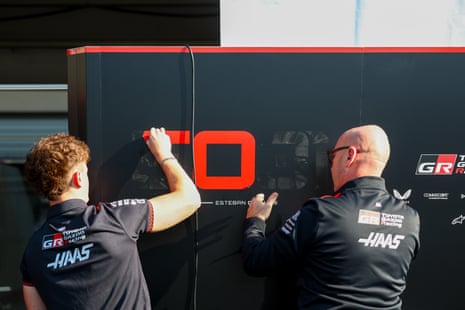 A team member removes the name and driver number of Esteban Ocon of France and Haas F1 from the garage