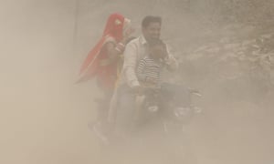 A family in Delhi ride through the thick smog.