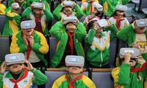 Chinese primary school pupils wear virtual reality headsets inside a classroom in Xiangxi.