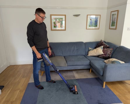 Reviewer Andy Shaw testing the Shark PowerDetect Speed Clean and Empty Pet Pro cordless vacuum Ultramarine IA3241UKT on a living room rug and hard floor.
