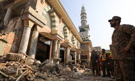 A soldier and rescue workers survey the damage after a suicide blast in a mosque in Peshawar, Pakistan, on Monday.
