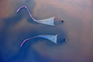 Shanxi, China: Two workers harvest brine shrimp in a salt lake