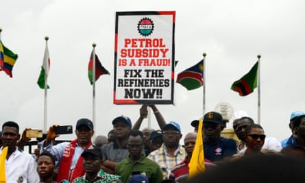 A group of people hold a banner saying ‘Petrol subsidy is a fraud. Fix the refineries now’ at a protest over fuel subsidy removal in Lagos, Nigeria