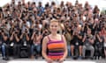 Scarlett Johansson posing in front of a large group of photographers.