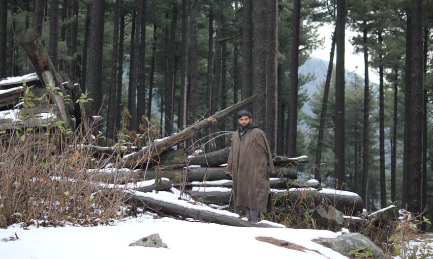 Abdul Aziz Khatana stands next to the wreckage of his forest hut at Lidroo.
